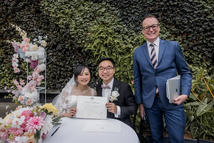 Affordable celebrant Chris Stedman with couple holding marriage certificate