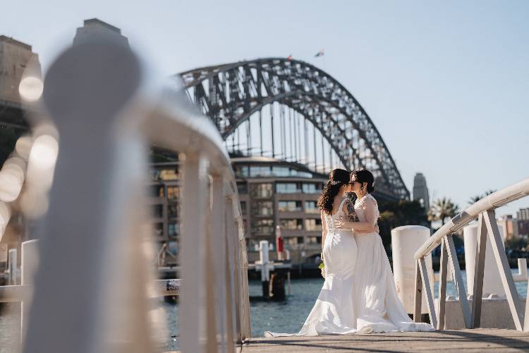 Newlyweds kissing with Sydney Harbour Bridge in background by Yasmina Nadine