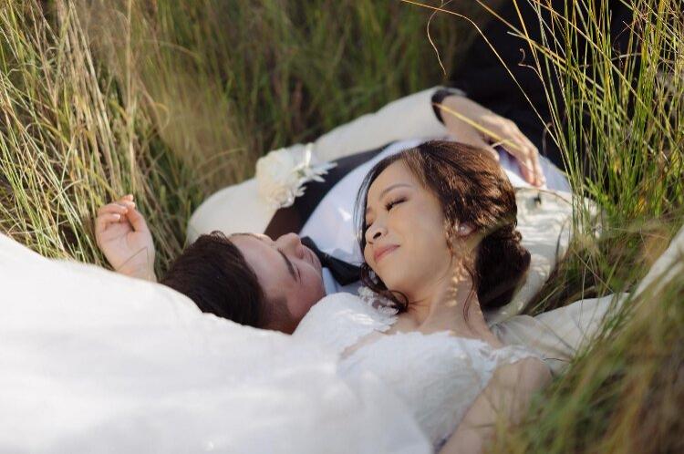 Wedding photo of couple in grass by Russell Stafford