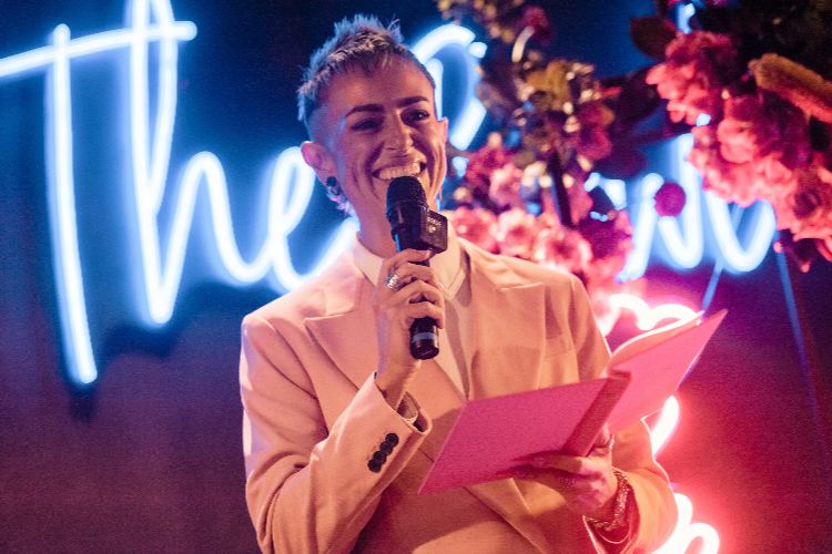 Sydney LGBTQ marriage celebrant Liz Watson smiling & officiating in a pink suit